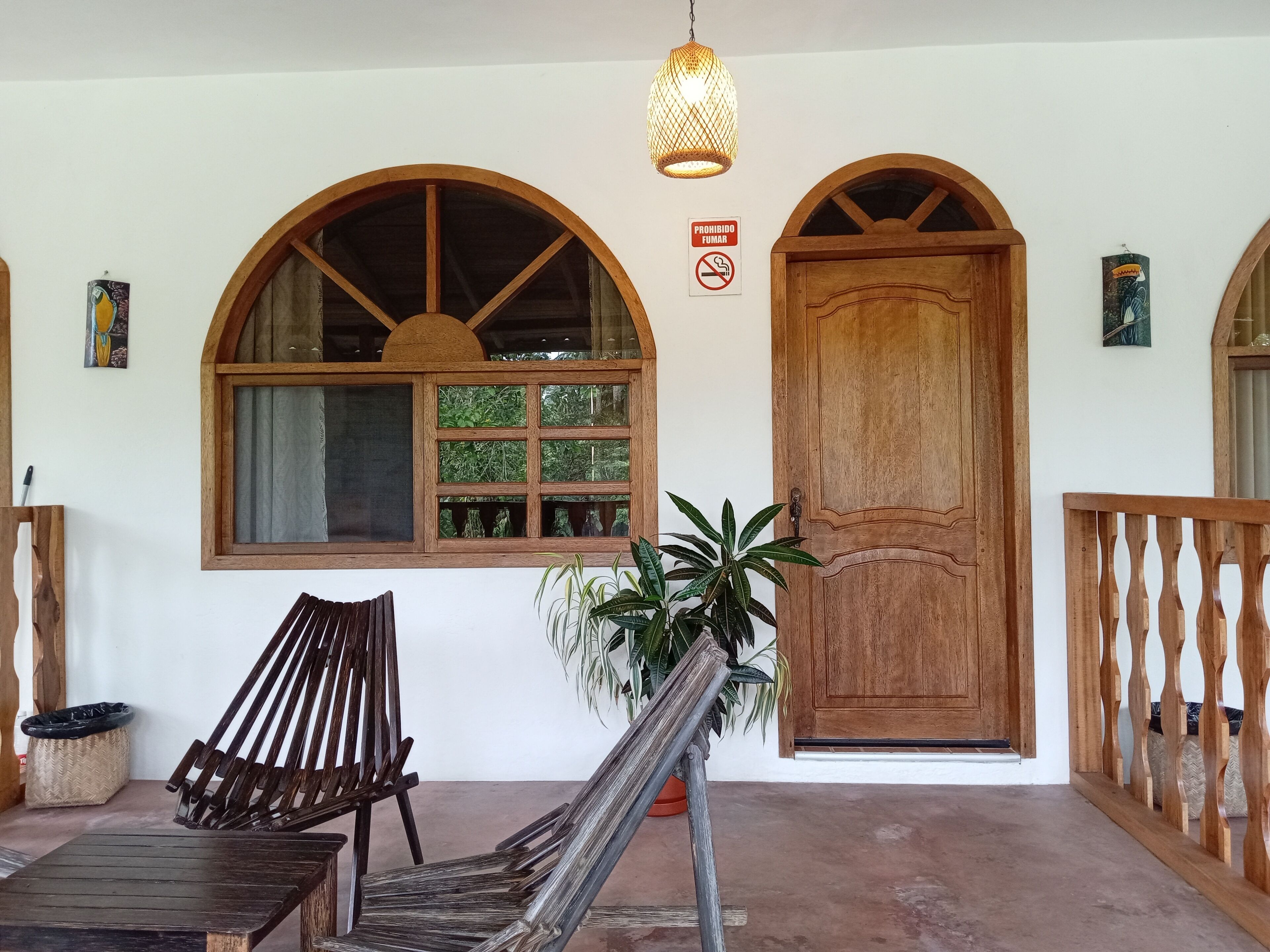 A wooden door with a glass panel, a bench, and a hanging light fixture.