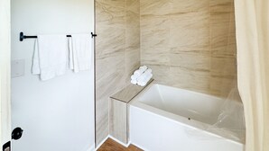 Une salle de bain moderne équipée d’une douche, d’une baignoire et d’un porte-serviettes avec des serviettes.