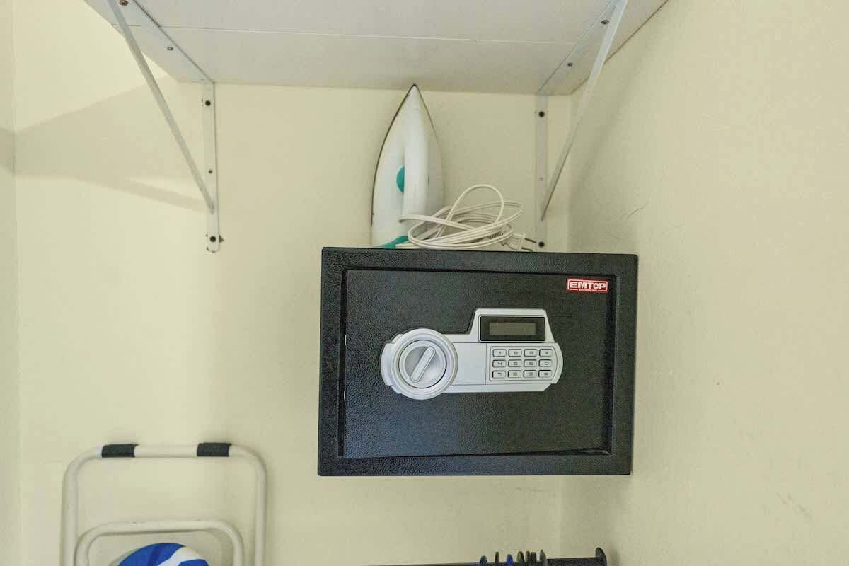 Una cassetta di sicurezza con serratura a combinazione, un'asse da surf e un cavo bianco.