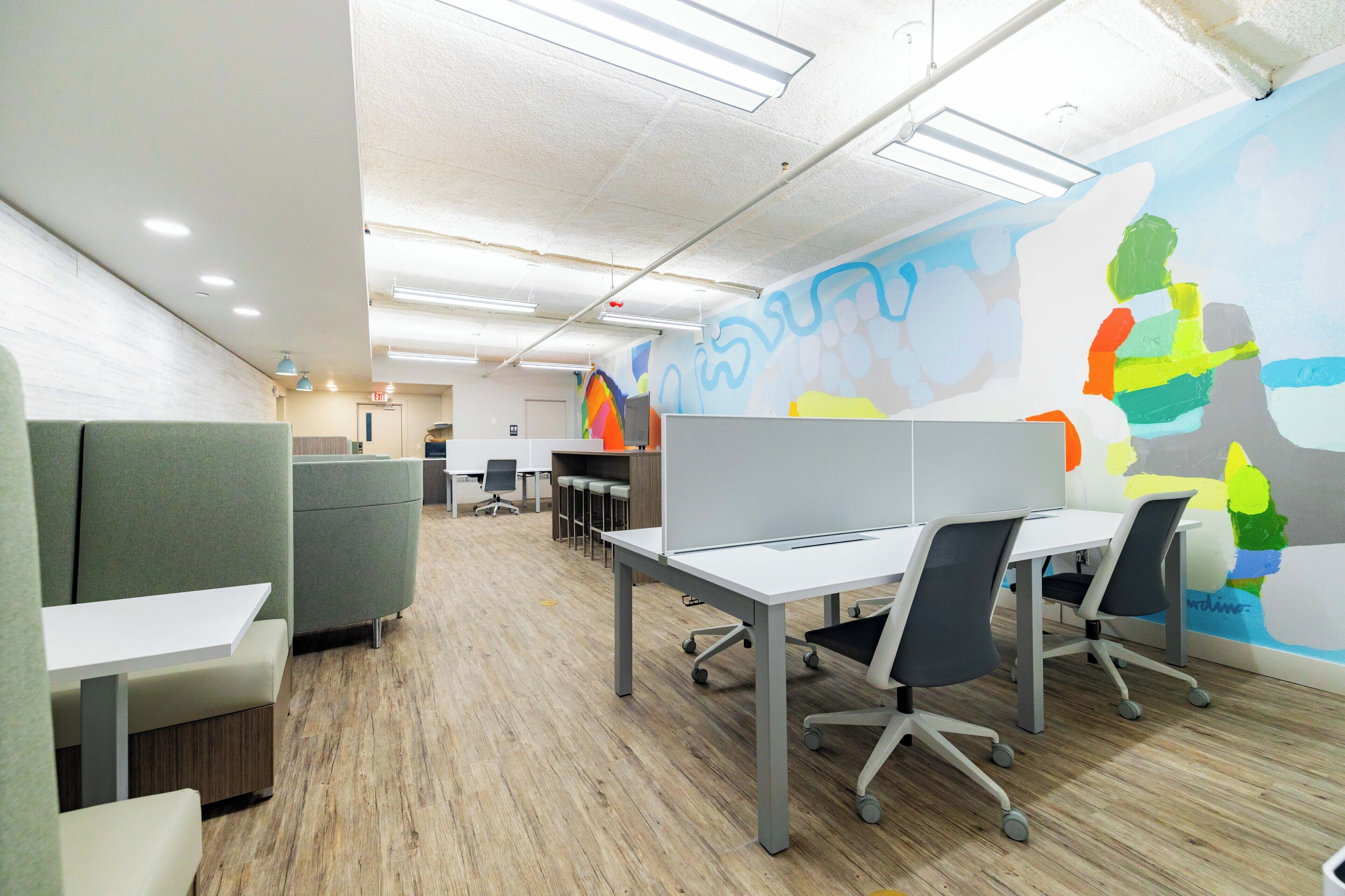 Un espace de bureau moderne, aménagé avec des cloisons, des bureaux et des chaises.