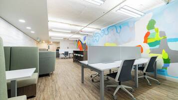 Un espace de bureau moderne, aménagé avec des cloisons, des bureaux et des chaises.