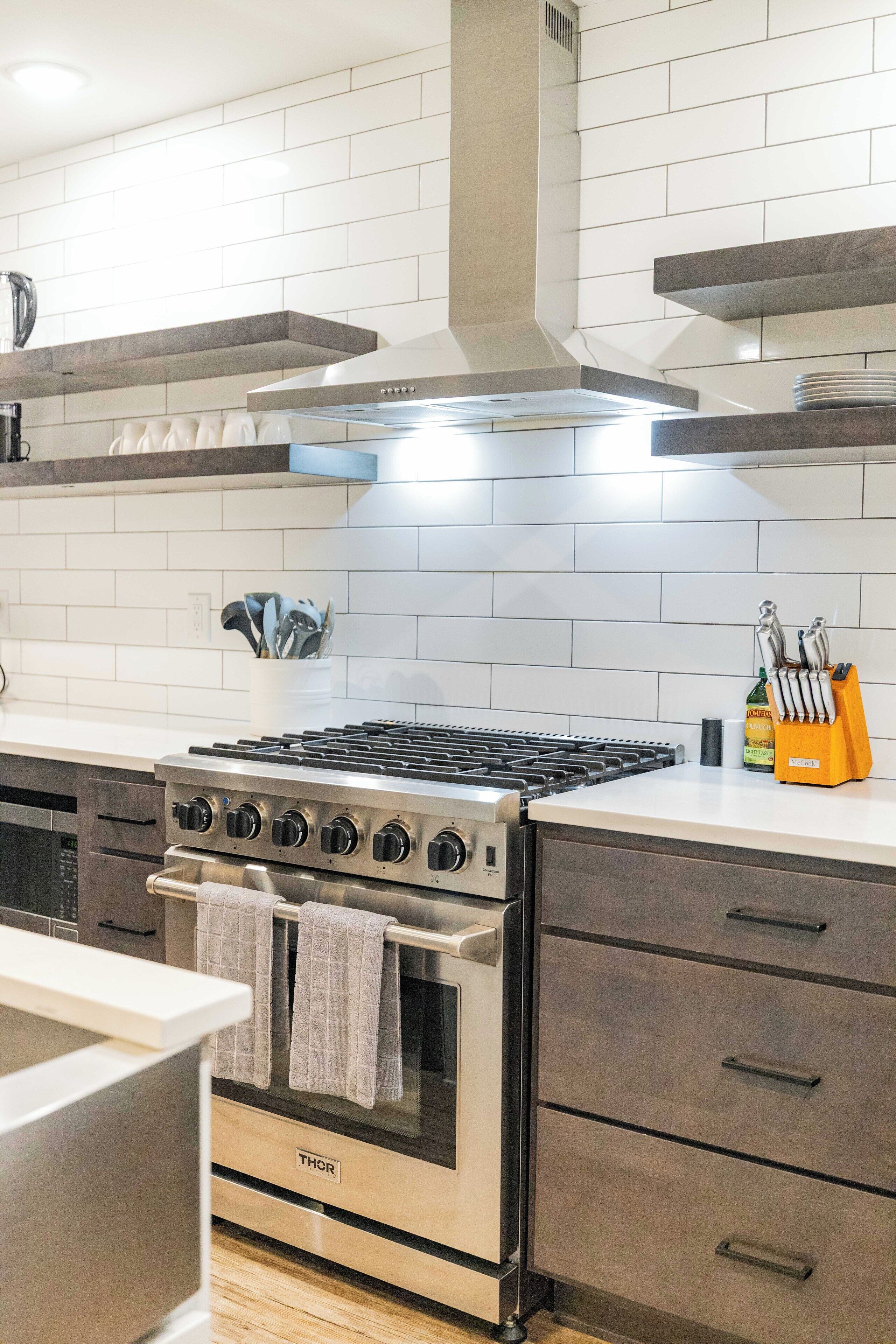 A kitchen with a stainless steel stove, oven, and modern cabinetry.