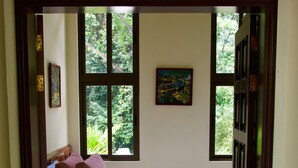 A bedroom with a bed, two pillows, a window, and a door. - Beautiful home and gardens near the beach (Ojochal)