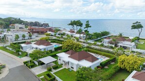Un quartier résidentiel en bord de mer, avec des maisons blanches, un restaurant et une vue sur la mer.