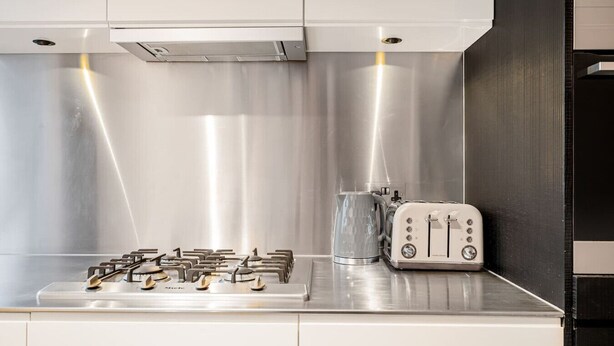Une cuisine moderne équipée d’appareils électroménagers en acier inoxydable, d’une bouilloire et d’un grille-pain.