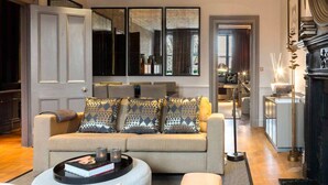 Un salon moderne avec un canapé, une table basse et une cheminée.
