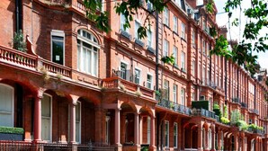 A row of red brick townhouses with arched windows and balconies, featuring a classic European architectural style. - Cadogan Square 3BR Prime Location (London)