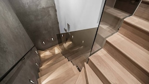 A modern staircase with wooden steps and glass railings. - Cadogan Square Penthouse Huge Terrace AC (London)