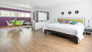 Ett modernt sovrum med en stor säng, ett skrivbord och en stol.