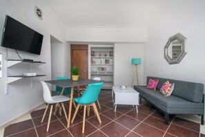 A modern living room with a TV, dining table, chairs, sofa, and a mirror. - Comfy APT W/Terrace @ La Roma (Mexico City)