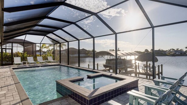 Piscina interna com cobertura de vidro, hidromassagem e espreguiçadeiras.