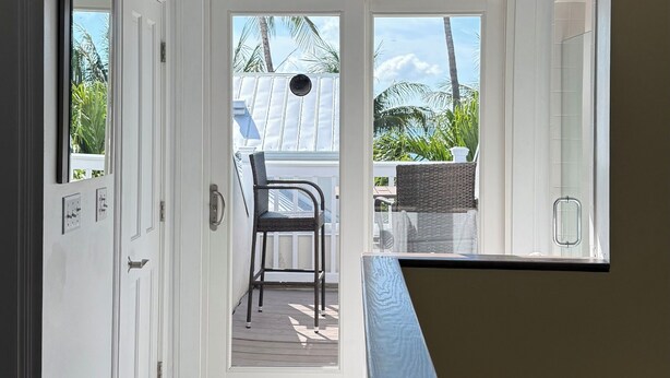 Quarto com ventoinha no teto, porta que dá para o exterior e vista para o ar livre.
