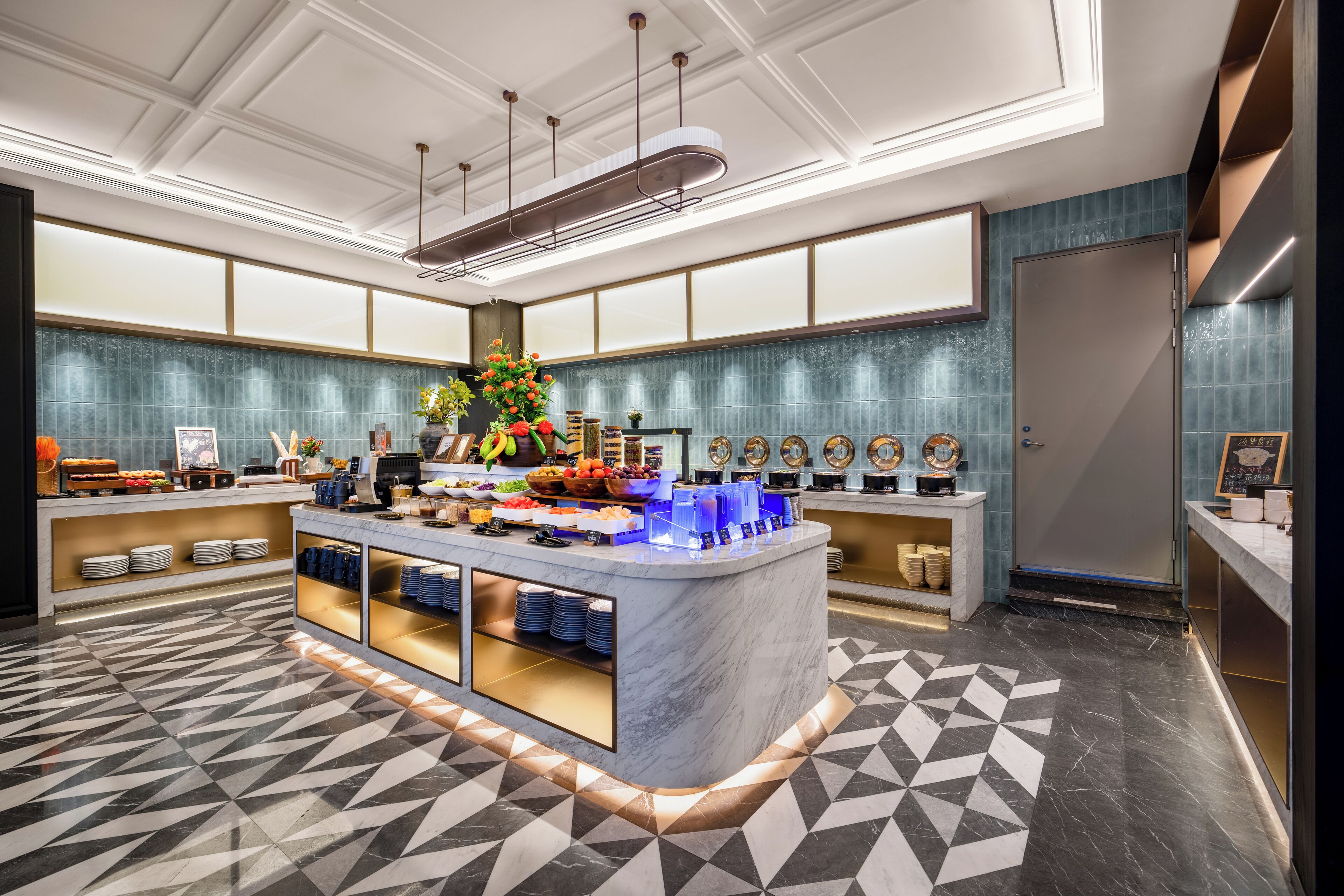 A modern hotel lobby with a marble reception desk, a buffet area, and a patterned floor.