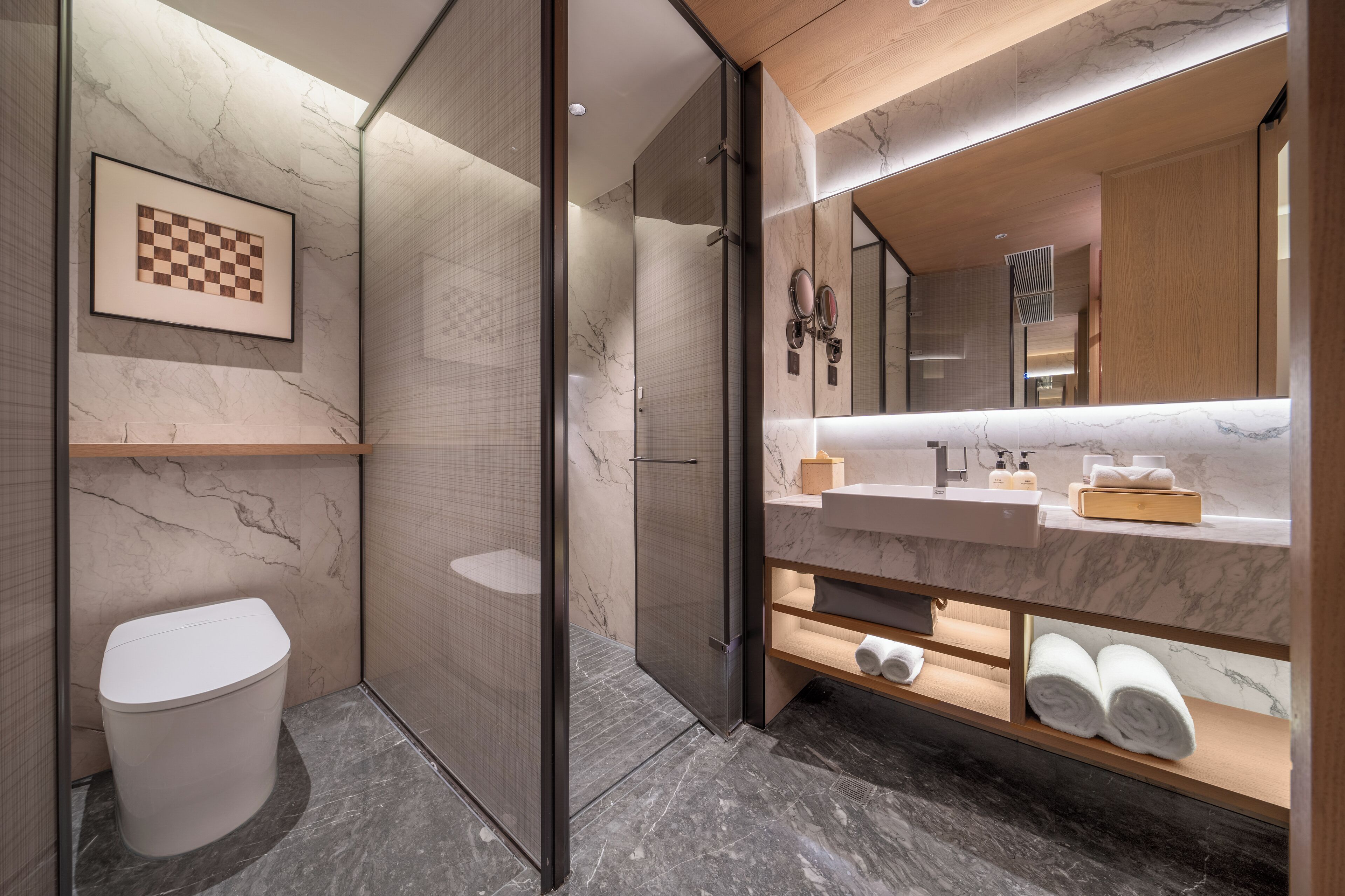 A modern bathroom with a marble vanity, a large mirror, and a framed chessboard on the wall.
