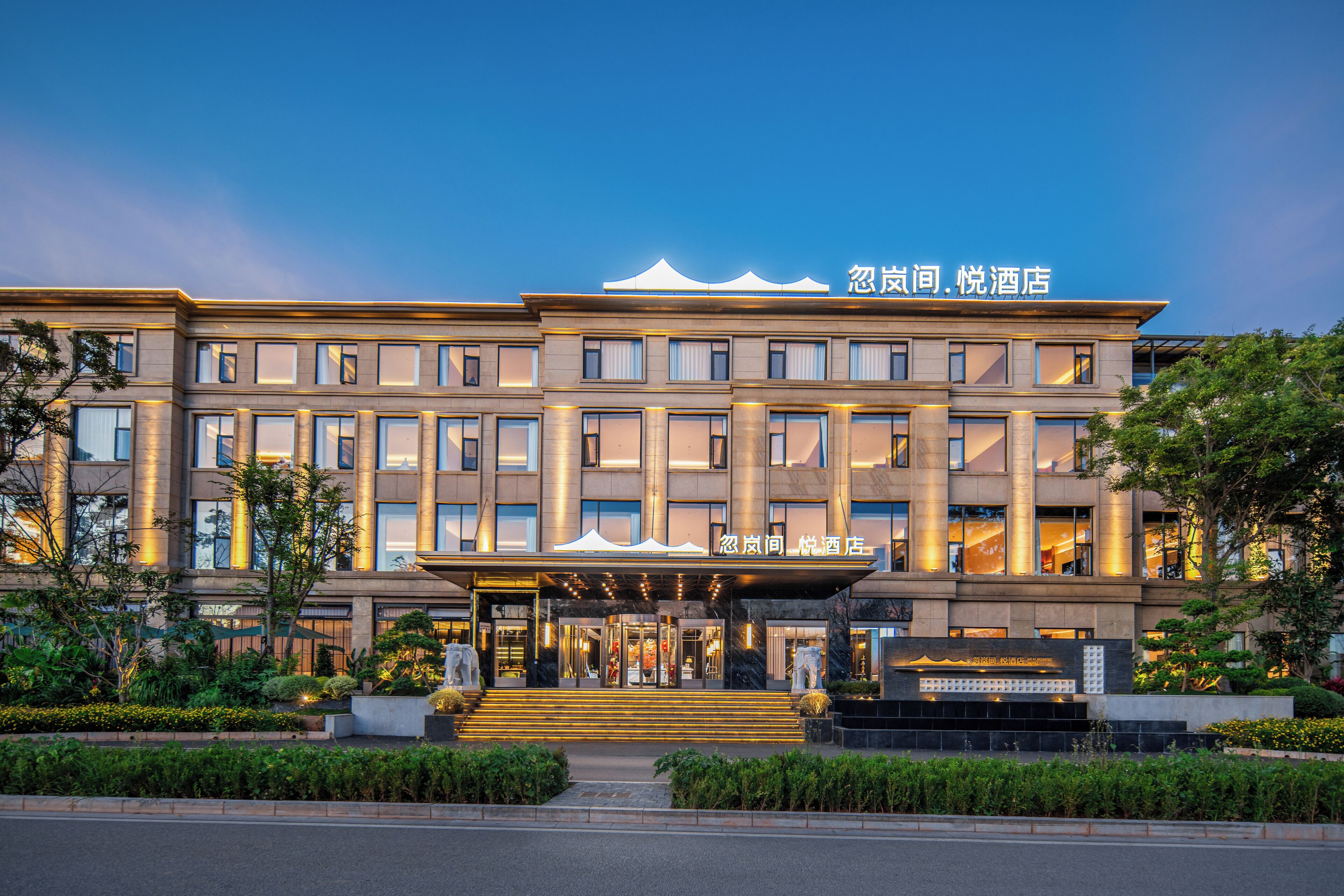 A modern hotel with a prominent entrance, multiple floors, and a well-lit facade.