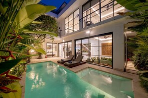 A modern house with a swimming pool, large windows, and outdoor seating. - Villa Samyati Kerobokan (Seminyak)