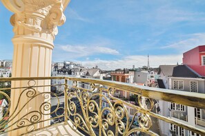A balcony with ornate metal railings overlooking a cityscape with various buildings. - Dalat Paradise Hotel (Xuan Huong - Da Lat)
