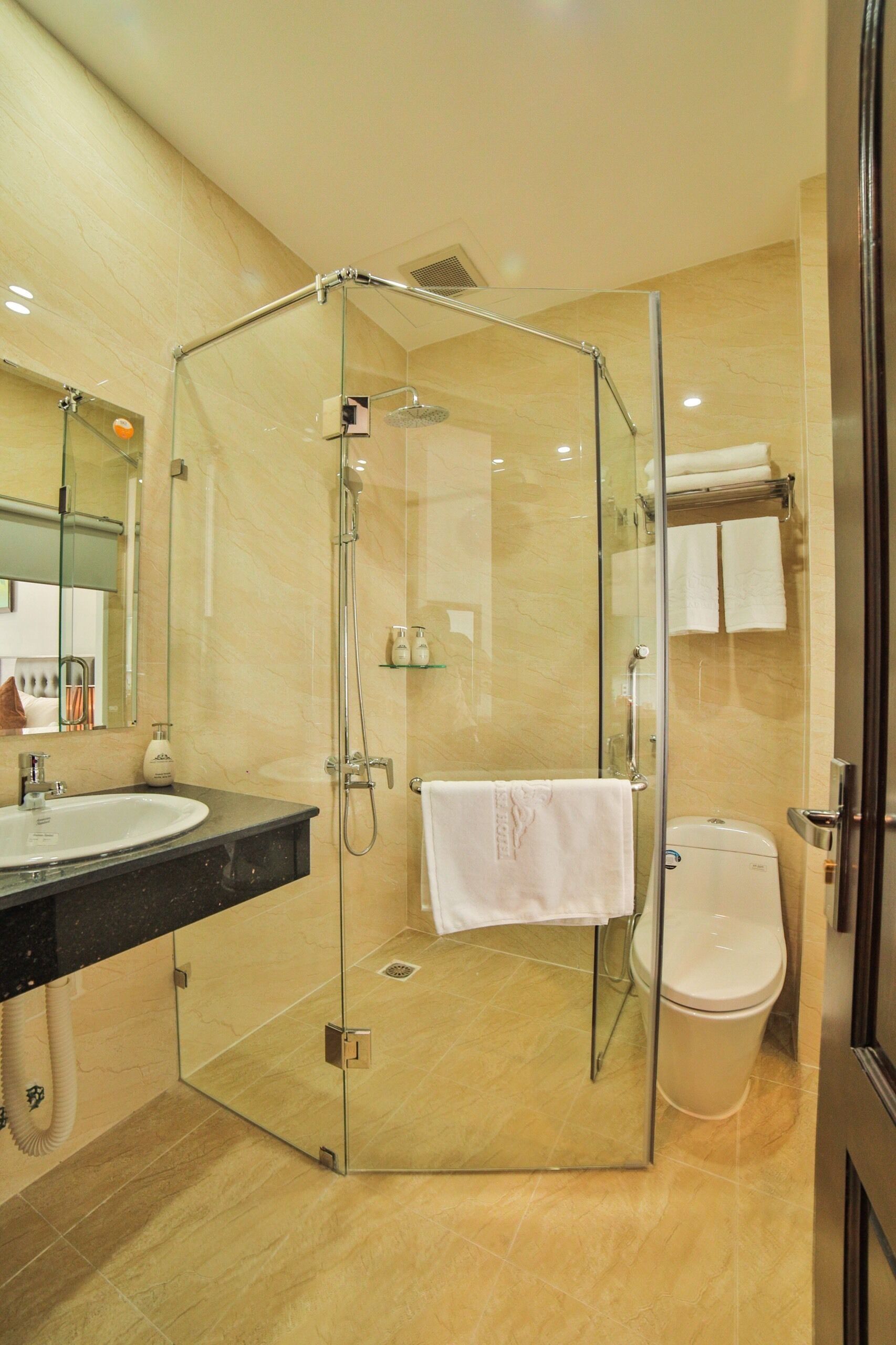 A modern bathroom with a glass-enclosed shower, a sink, and a toilet.
