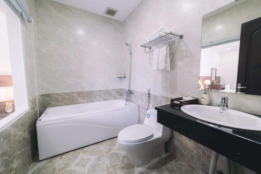 A modern bathroom with a bathtub, toilet, and sink.
