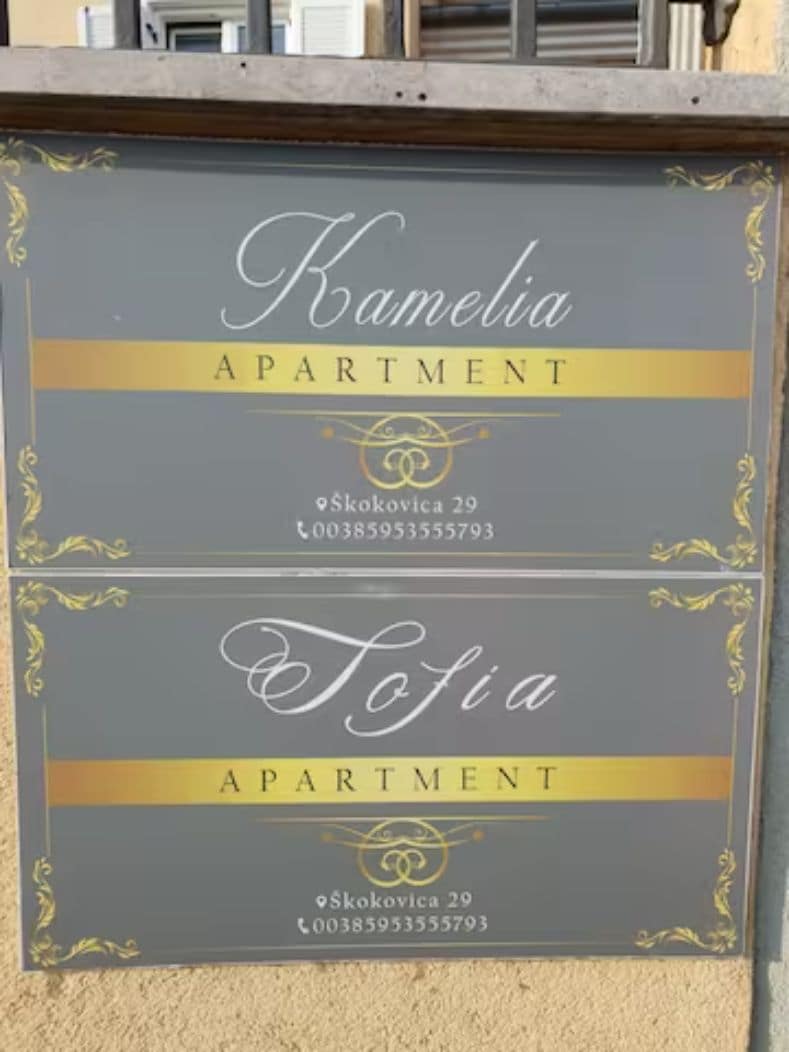 Duas placas de apartamentos, Kamelia e Tofia, com informações de contato e endereço.