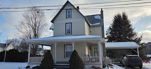 A two-story house with a porch, a covered front entrance, and a car parked in the driveway. - Welcoming 3-bedroom house in charming Canton PA (Canton)
