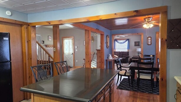 A kitchen with a central island, wooden cabinets, and a dining area with a table and chairs. - Welcoming 3-bedroom house in charming Canton for your getaway (Canton)