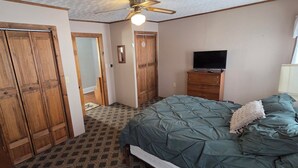 A bedroom with a bed, a television, a ceiling fan, and wooden wardrobes. - Welcoming 3-bedroom house in charming Canton for your getaway (Canton)