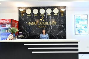 A reception desk at Hanoi Starlight Hotel with a black marble backdrop featuring clocks and city names. - Hanoi Blue Sky Hotel (Hanoi)