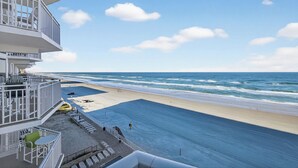 A beachfront hotel with a pool, outdoor seating, and a view of the ocean. - Coastal Daydream At White Surf (Daytona Beach)