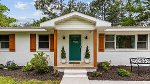 A two-story house with a green front door, white exterior, and wooden shutters. - The Charming Pines Hideaway - 3B/2B - Golfer's Paradise (Southern Pines)
