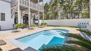 A modern building with a pool, outdoor seating, and bicycles. - Edge of Rosemary Beach + 1 Minute Walk to Beach | Pool, Putting Green, Carriage House (Rosemary Beach)