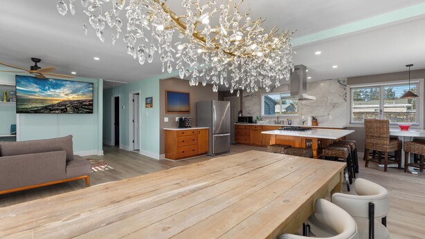 A modern kitchen with a wooden island, stainless steel appliances, and a chandelier. - Spacious 4-bedroom Ranch Cape May Oasis Master Spa Hot Tub (Cape may)