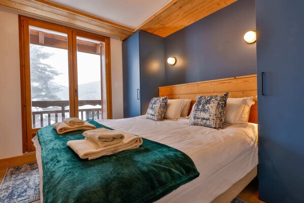 Ein Schlafzimmer mit einem Bett, Kissen, einer grünen Decke und einem Holzkopfende.