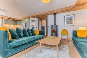 Ein gemütliches Wohnzimmer mit einer Couch, einem Couchtisch und einem Kamin.