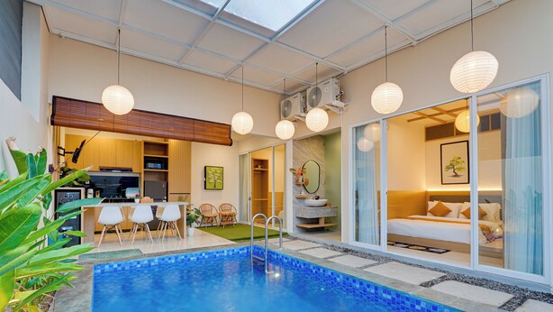 A modern indoor pool area with a clear view of a bedroom and a dining area. - Villa D'Bonzai - Nusa Dua (Nusa Dua)