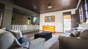Un salon spacieux avec un plafond en bois, un canapé, une table basse et un meuble en bois.