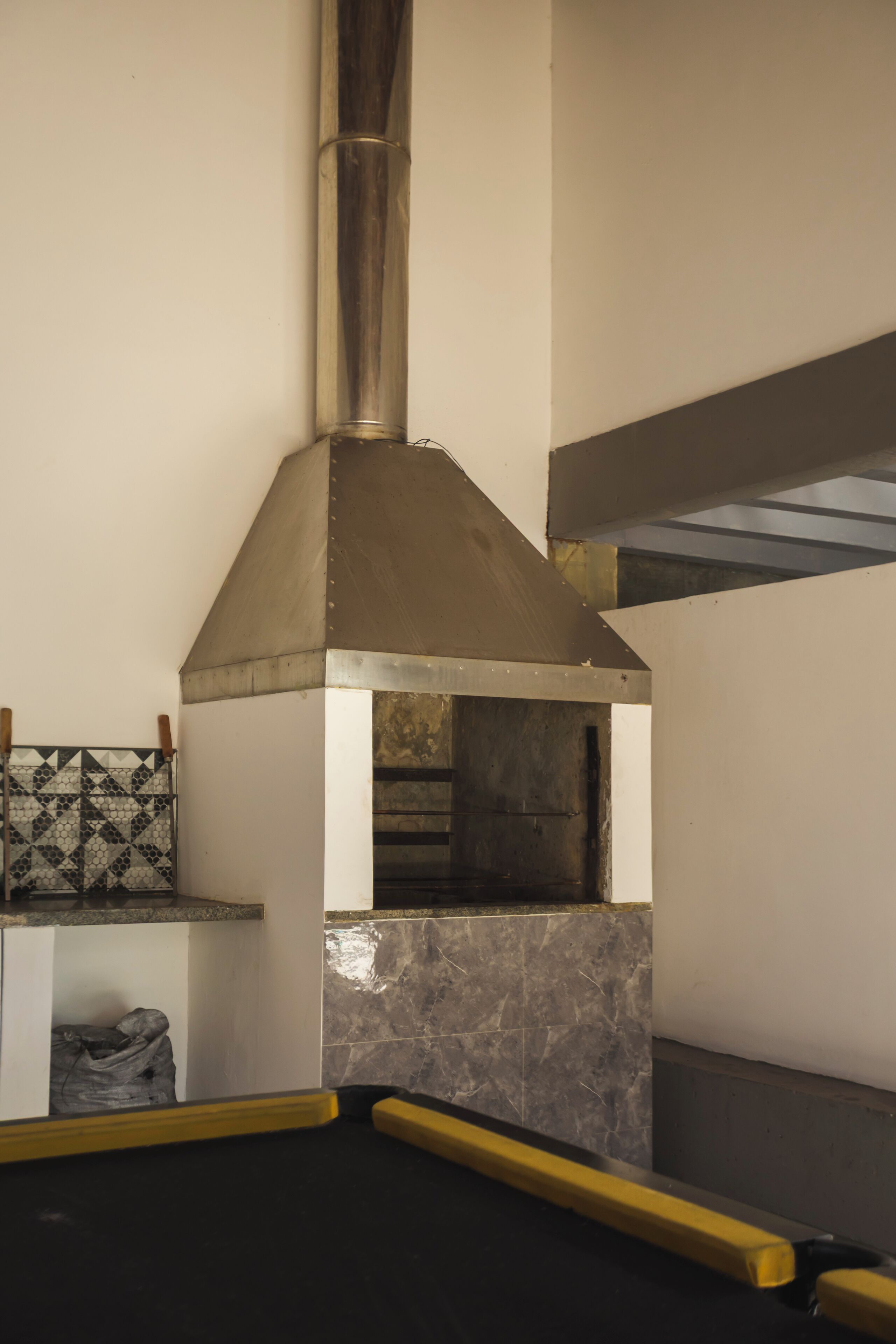 A kitchen with a stainless steel range hood, a tiled backsplash, and a marble countertop.