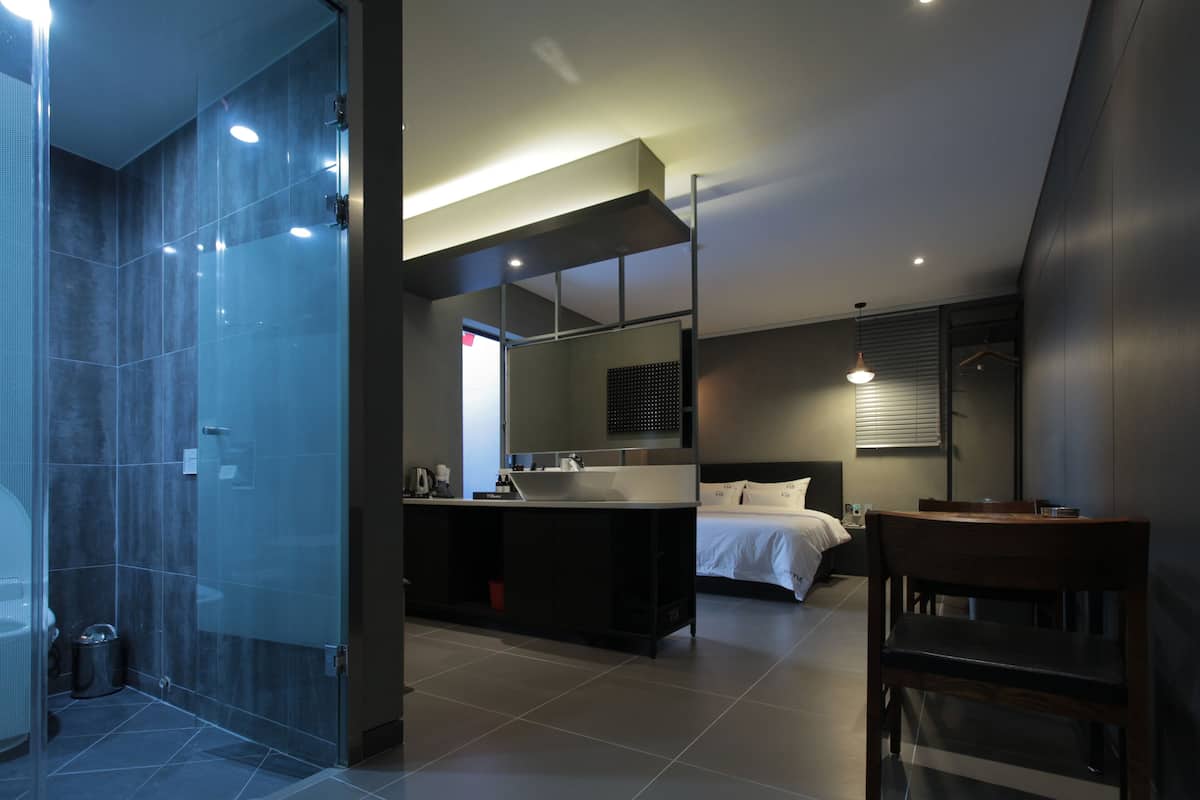 Une salle de bain moderne avec une douche à parois de verre, un grand miroir et un espace lavabo.