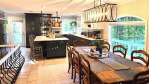 Una cocina moderna con armarios oscuros, electrodomésticos de acero inoxidable y una isla grande.