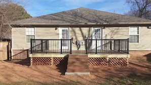 A single-story house with a front porch, a small front yard, and a wooden fence. - Cozy Pet-Friendly 3BR Duplex with Fast WiFi only Minutes to Casino (Fort Smith)