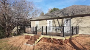 A single-story house with a front porch, a small deck, and a brick foundation. - Cozy Pet-Friendly 3BR Duplex with Fast WiFi only Minutes to Casino (Fort Smith)
