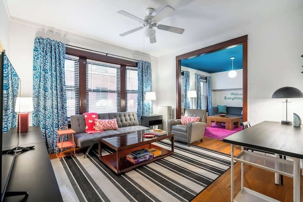 A modern living room with a sofa, coffee table, and a dining area. - Keepin’ it Golden at Wrigley (Chicago)