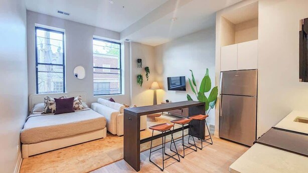 Un appartement moderne comprenant une cuisine, un coin repas et un salon avec un canapé et une table basse.