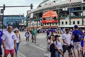 A stadium with a large sign reading "Wrigley Field Home of Chicago Cubs" and "Chicago Tribune Proud Partner of the Chicago Cubs". - The Nook • Vintage Flat Near Wrigley (Chicago)