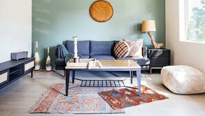 A modern living room with a blue sofa, a coffee table, and a round woven wall hanging. - Modern and Relaxing Sedona Oasis - Bedouinn (Sedona)