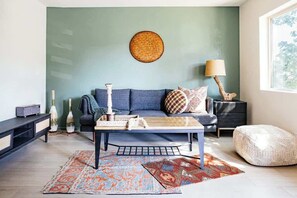 A modern living room with a blue sofa, a coffee table, and a round woven wall hanging. - Modern and Relaxing Sedona Oasis - Bedouinn (Sedona)