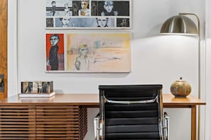 A modern office space with a desk, a black office chair, and artwork on the wall. - Toad Hall near Wrigley (Chicago)