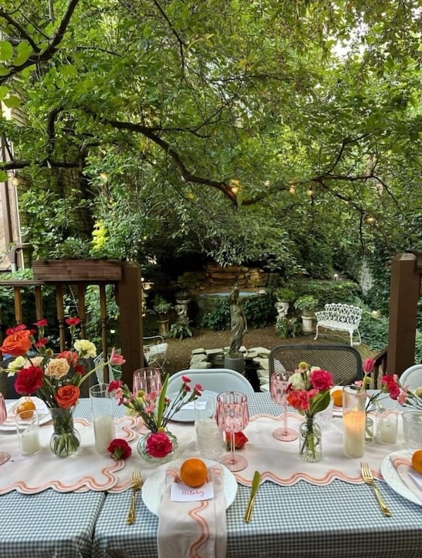 An outdoor dining area with checkered tablecloths, glassware, and floral centerpieces. - One-of-a-Kind Apartment In Old Town! (Chicago)