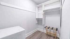 A small, white-walled room with a wooden floor, a white radiator, and a wooden drying rack. - Studio Beau - Steps from Lincoln Park Zoo & Lake (Chicago)