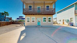 A two-story building with a balcony, a door with a number, and a small patio area. - GV628, Shared Pool, Pet Friendly, Charcoal Grill, Close to Beach (Port Aransas)